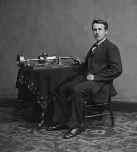 Image of Thomas Edison at an early version of the phonograph