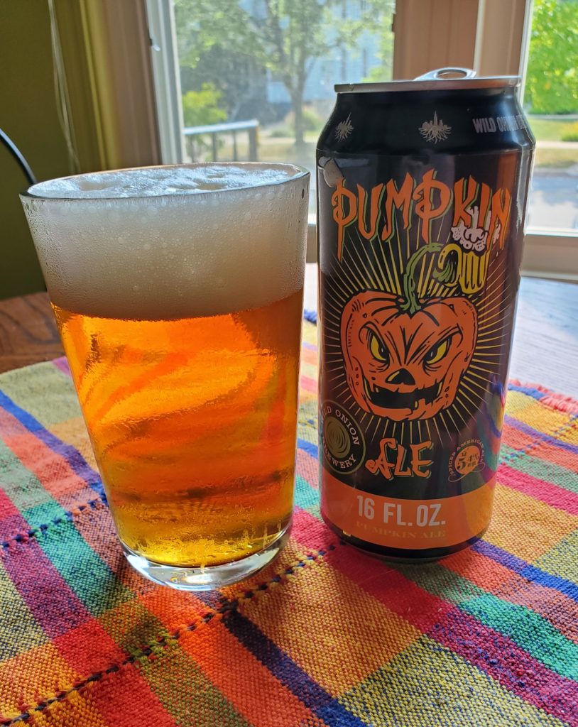 Photo of a pint glass of Wild Onion Brewery's Pumpkin next to the beer can. 