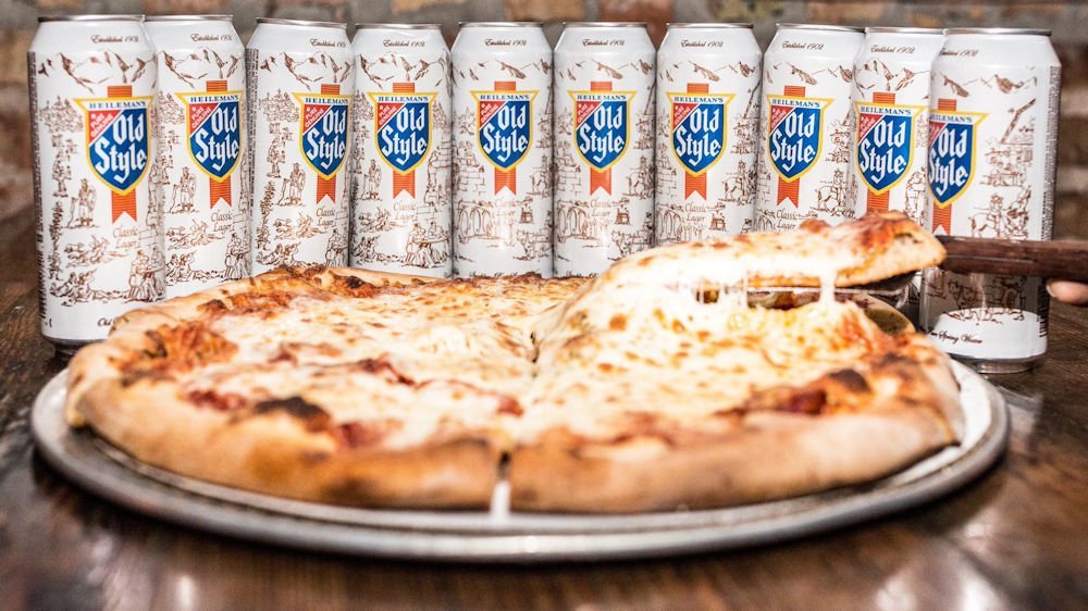 Image of 10, 16 ounce cans of Old Style arranged as a backstop around a pan of cheese pizza