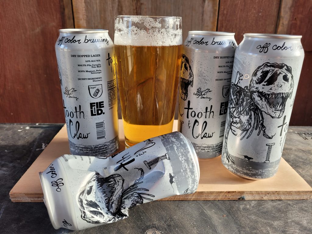 Photo of four 16 oz cans and a full glass of Tooth & Claw Czech-style lager made by Chicago's Off Color Brewing